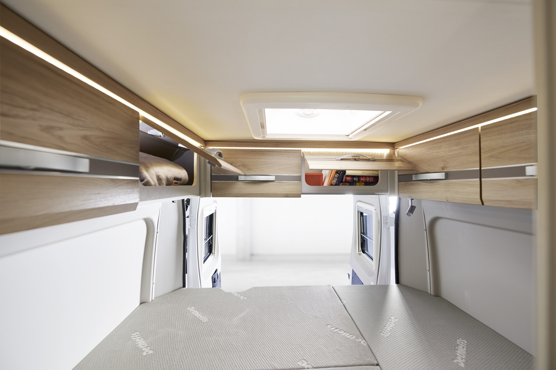 Los armarios altillos sobre las puertas traseras ofrecen espacio de almacenamiento adicional y disponen de iluminación indirecta.